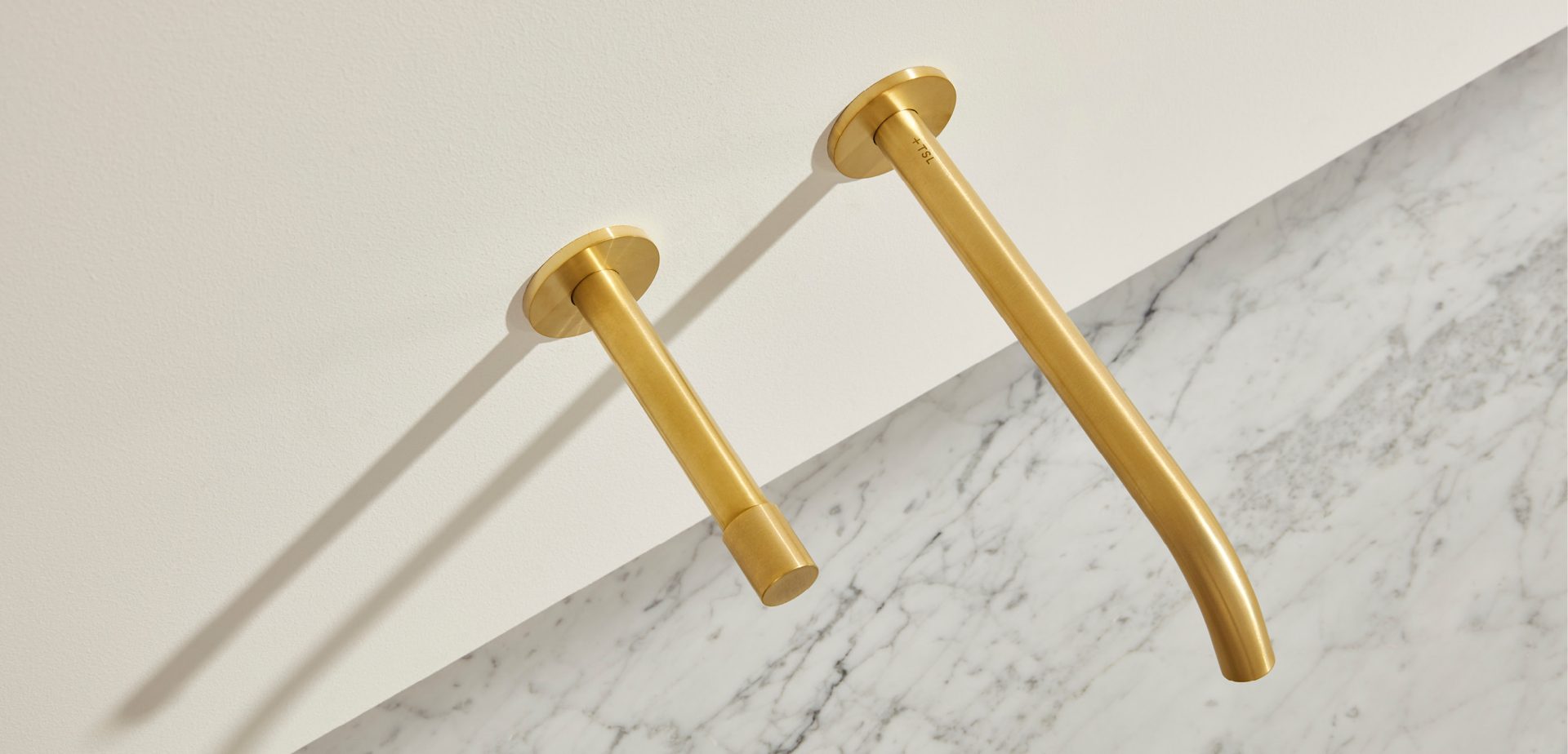 The Aerofoil sink in Carrara marble with brass taps by The Splash Lab